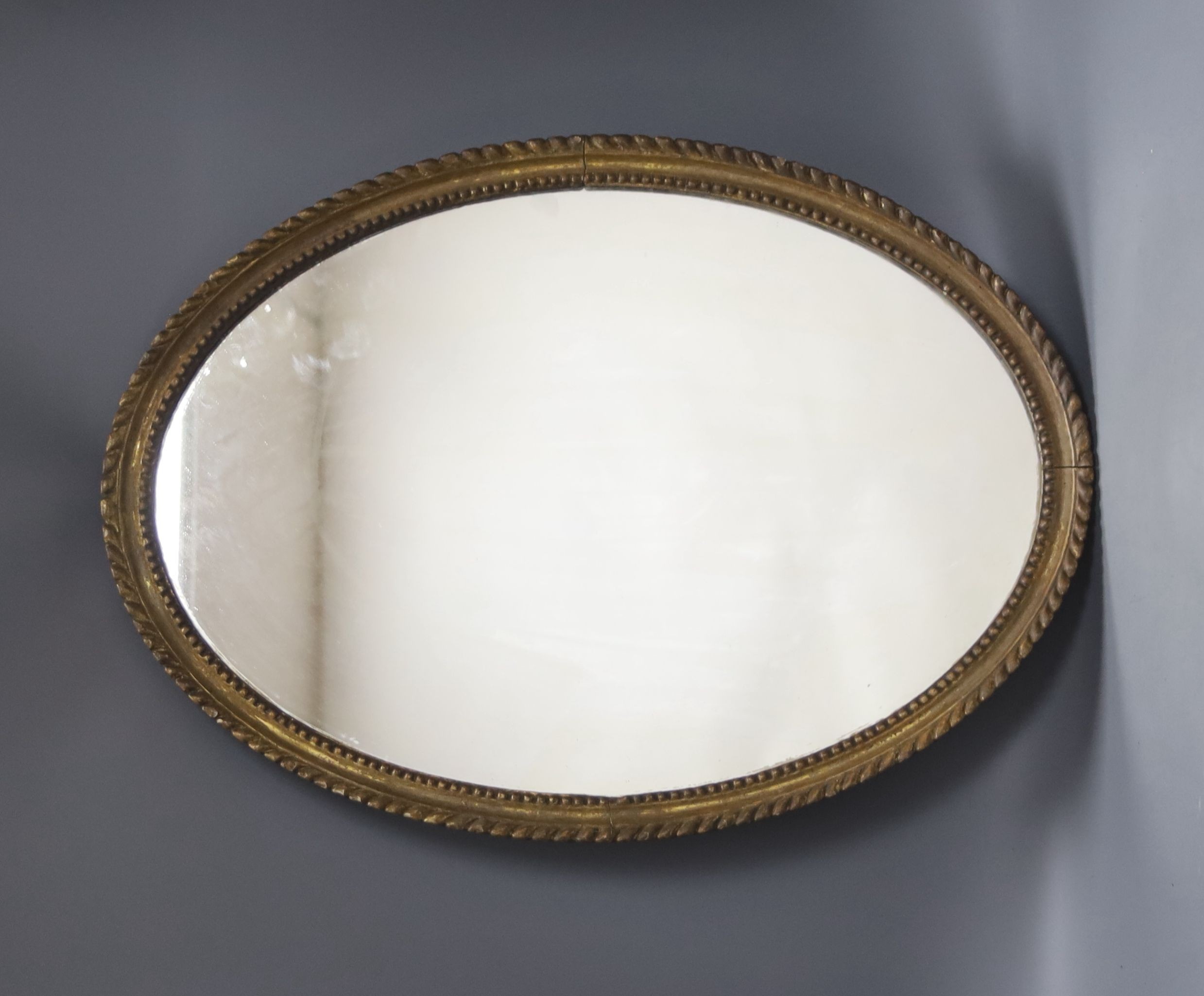 An oval gilt framed wall mirror, 55.5 cm high